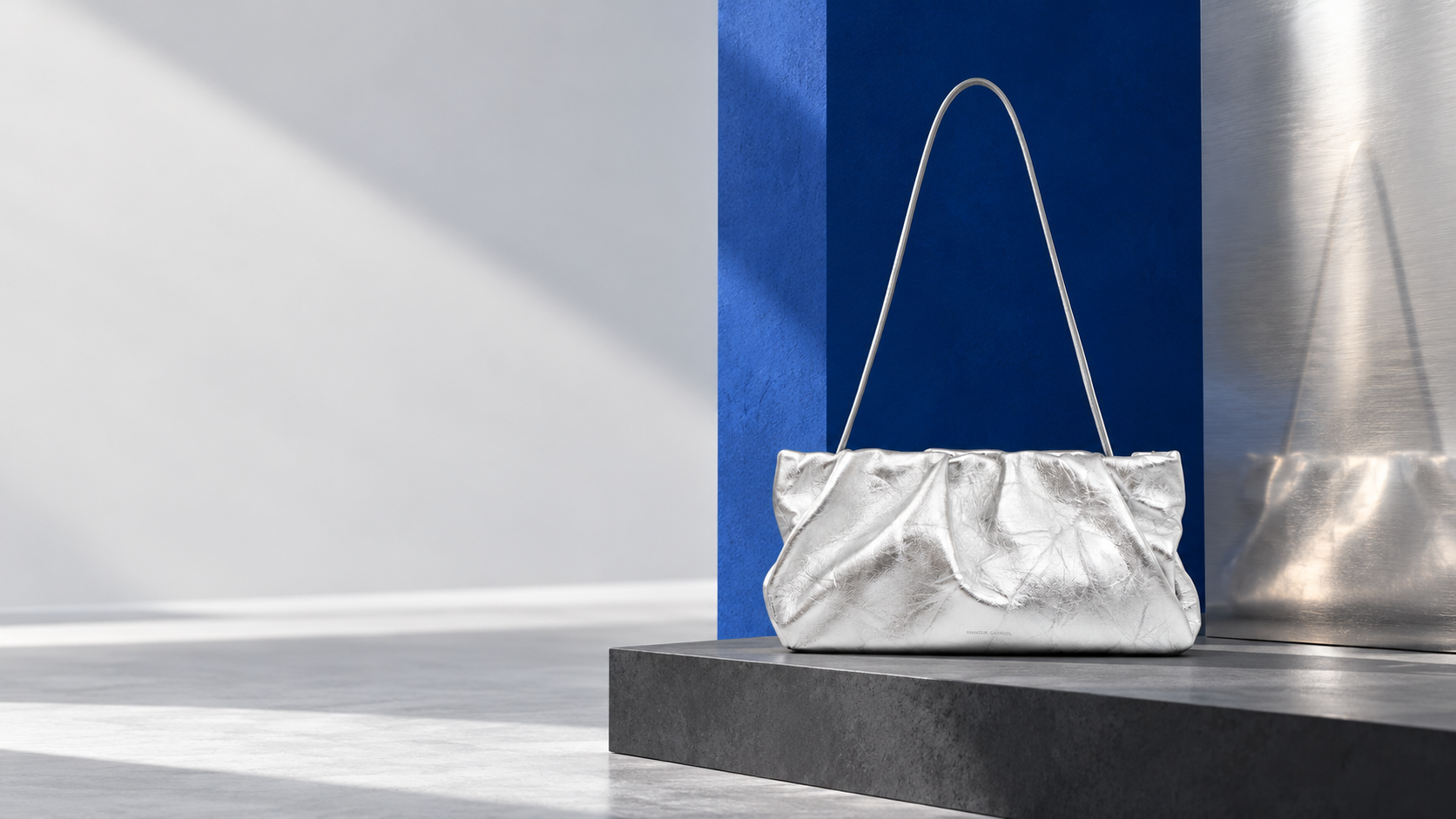 Silver gathered shoulder bag in a cobalt and charcoal editorial setting