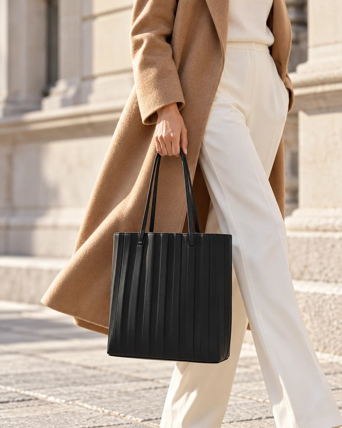 Black pleated tote styled with a camel coat